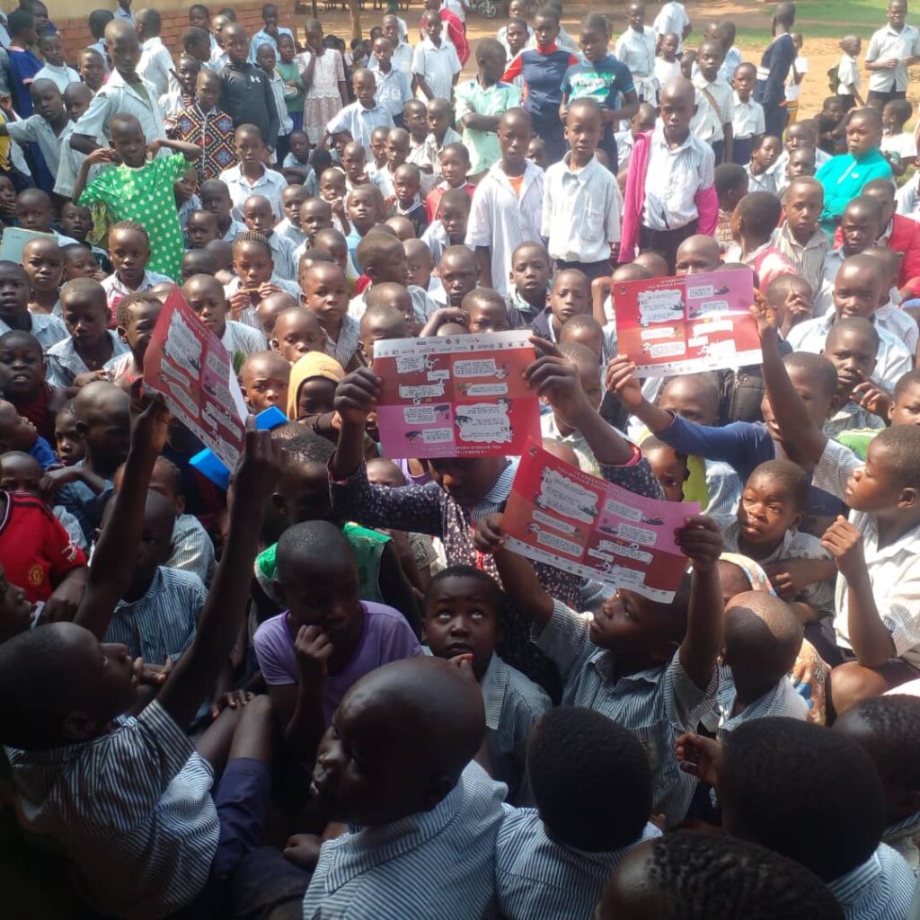 Pupils show the ICEA materials during rabies control outreach at Buchicha PS